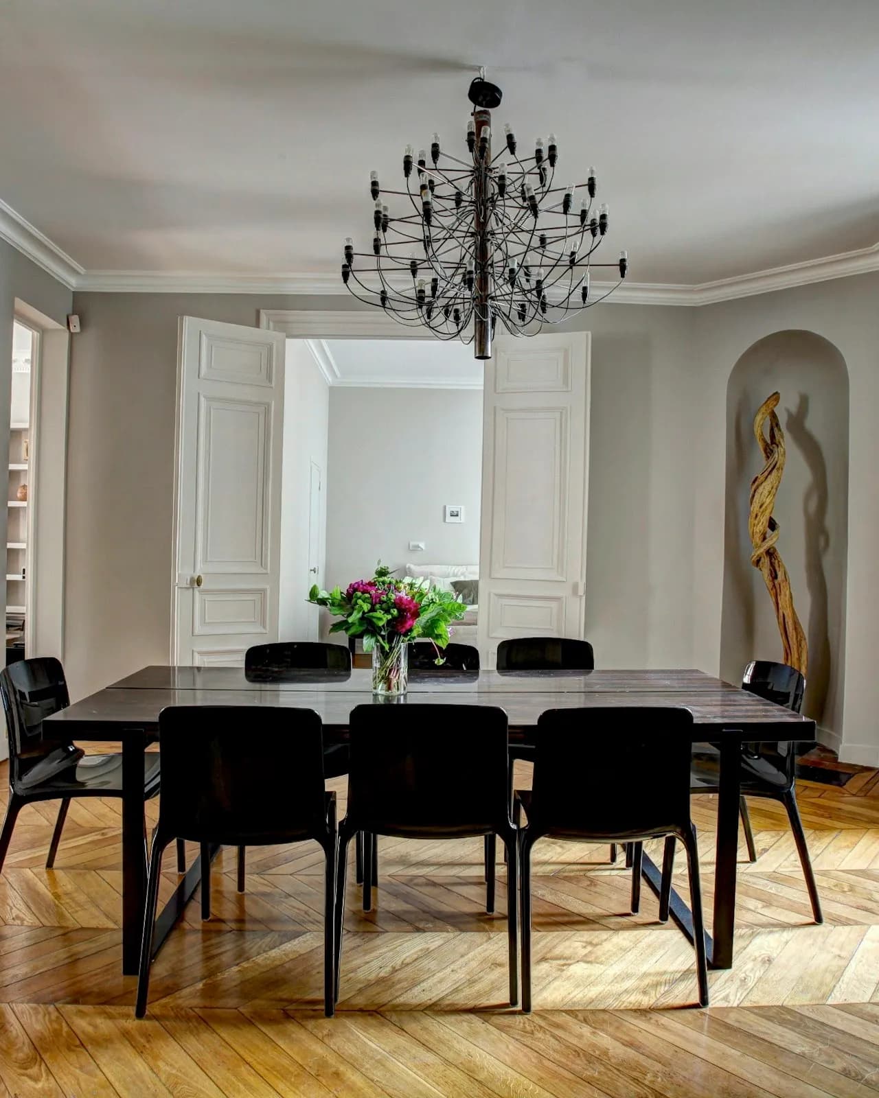 Le double séjour d’un appartement ancien : parquet en point de Hongrie, moulures, grande table.